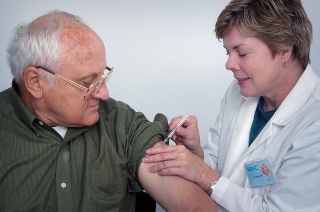 médica vacunando a un hombre mayor