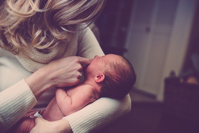 bebé que llora en los brazos de su madre